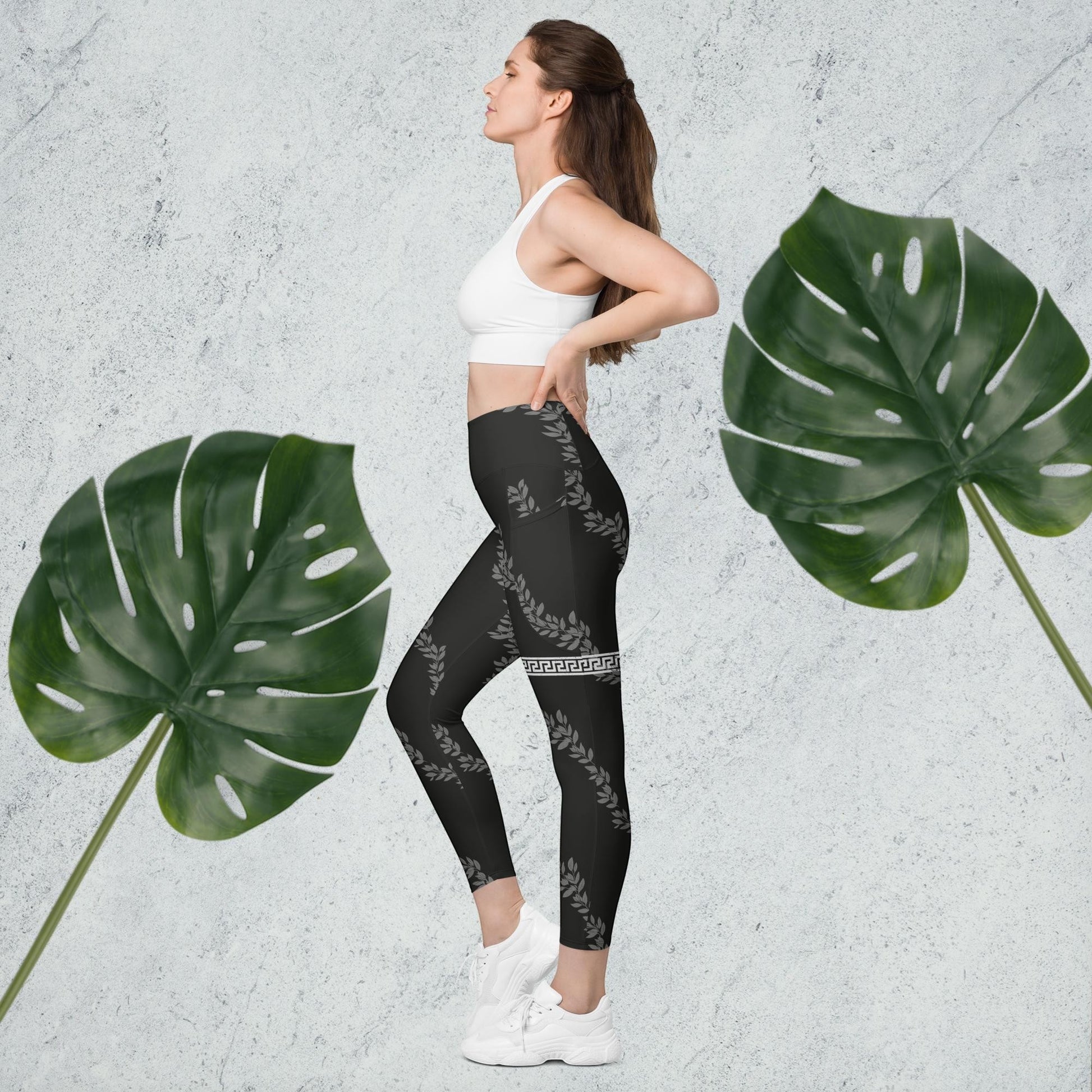 Immortal Krav Maga Unyielding Leggings w/ Pockets. Black leggings with a laurel wreath pattern and Greek key border. High-waisted, tight fit, 75% recycled polyester.
